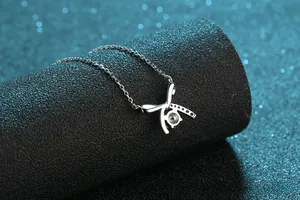 Close-up of S925 silver necklace with sparkling bow pendant and round center stone