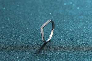 Macro shot of V-shaped S925 silver ring with pavé moissanite on a blue starry background