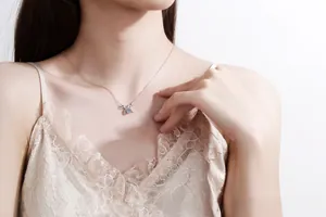 Close-up of S925 silver bow pendant necklace with round moissanite on a model