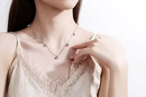 Détail du collier en argent S925 avec moissanite et pendentifs floraux sur le cou