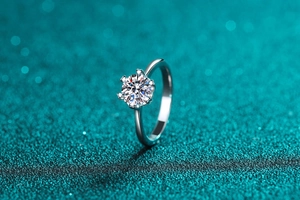 Macro shot of silver ring featuring six-prong moissanite setting with brilliant cut gem