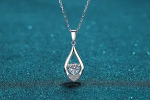 Macro view of S925 silver necklace with teardrop pendant and sparkling round gemstone