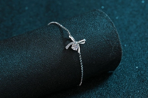 Detail of S925 silver bracelet featuring a bow charm with sparkling moissanite stone
