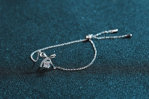 Close-up of S925 silver bracelet with sparkling bow charm and adjustable sliding bead clasp