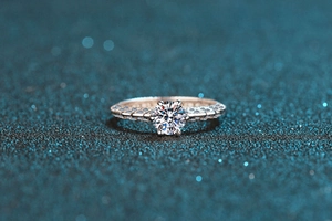 Detail view of round moissanite ring with twisted pavé band on starry blue background