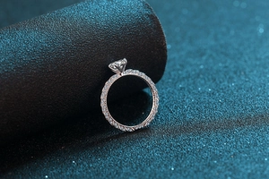 Macro side view of a 925 silver moissanite ring with twisted pavé band and six-prong setting