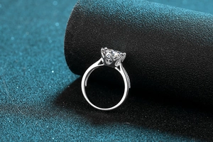 Macro shot of 3 carat moissanite ring with six-prong setting and side diamond accents