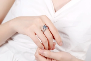 Détail d'une bague moissanite à six griffes avec un anneau double serti de petits diamants