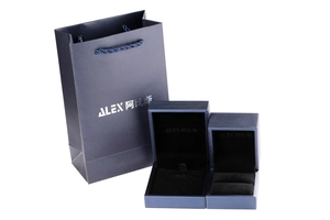 Navy blue jewelry gift set featuring a textured paper bag and two hinged boxes