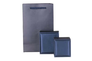 Detailed view of textured navy blue jewelry gift box set with matching paper bag and ribbon