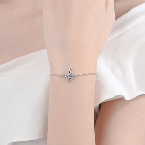 Elegant S925 sterling silver bow bracelet with a bright blue moissanite gemstone on a wrist