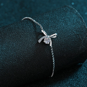 Elegant S925 sterling silver bow bracelet with moissanite center stone on dark display