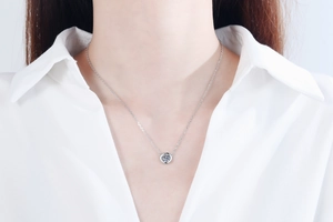 Detail of S925 silver bezel set 1 carat moissanite solitaire necklace on model