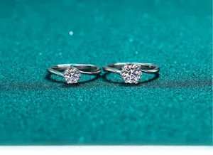 Gros plan de deux bagues en moissanite à six griffes avec anneaux torsadés sur fond vert