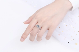 Elegante anello in argento con moissanite taglio rotondo indossato su sfondo di tulle