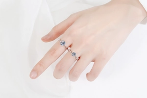 Détail de deux bagues en argent 925 avec moissanite et anneau torsadé sur de la soie