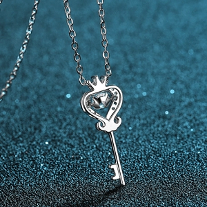 S925 sterling silver crown key necklace with dancing moissanite pendant on blue background