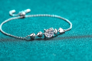 Close-up of S925 sterling silver bracelet featuring heart charms and a moissanite center