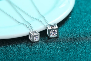 Macro shot of silver cube pendant necklaces with clear round-cut moissanite stones