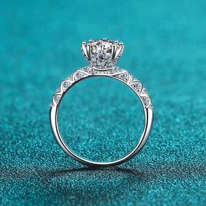 Anello in argento S925 con moissanite e fascia traforata su sfondo blu glitterato