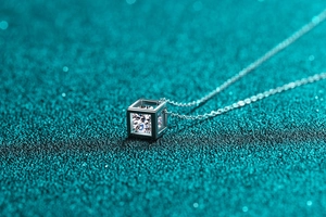 Macro shot of a minimalist square pendant necklace with a sparkling Moissanite stone