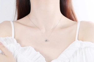 Close-up of a square moissanite pendant on a S925 silver chain worn by a model