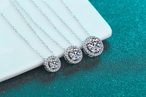 Vue détaillée de trois pendentifs ronds en moissanite de différentes tailles sur argent
