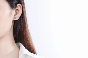 Close-up of a S925 sterling silver stud earring with a brilliant round moissanite on ear