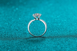 Macro shot of 925 silver moissanite ring with six-prong setting and pavé side stones