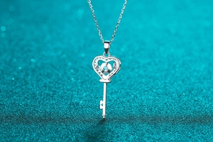 Makroaufnahme einer 925er Silber Herz-Schlüssel-Halskette mit blauem Moissanit-Edelstein