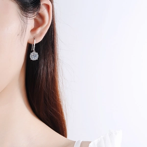Elegant S925 sterling silver four-prong moissanite drop earrings worn by a model