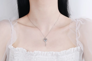 Detail der 925 Silber Herzschlüssel-Kette mit hellblauem Edelstein am Modell