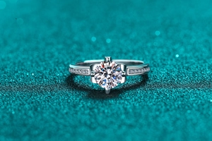 Macro shot of crown moissanite ring showing brilliant round cut center stone and side diamonds