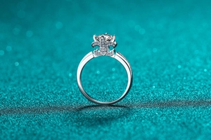 Macro view of crown-shaped moissanite ring with brilliant round center stone and pave band