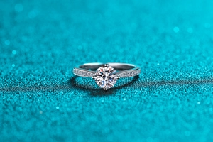 Macro shot of S925 sterling silver moissanite ring with six-claw setting and side stones