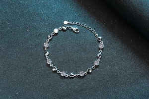 Macro view of S925 silver moissanite bracelet with heart links and lobster clasp