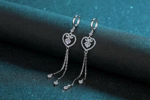 Macro shot of S925 silver heart tassel earrings with moissanite accents and chain details