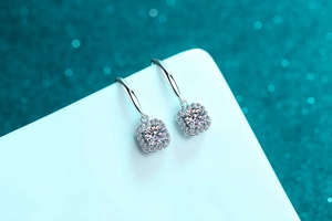 Detail of S925 silver halo earrings with square moissanite drops on teal background