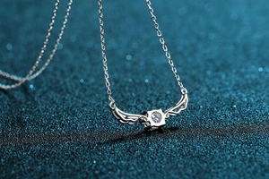 Close-up of S925 sterling silver angel wing necklace with a sparkling round moissanite