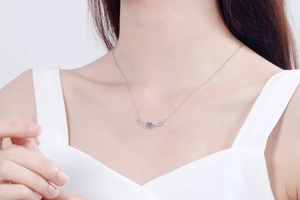 Elegant angel wing pendant necklace with round moissanite on a model's collarbone