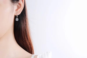 Close-up of S925 silver halo drop earrings with square moissanite on model ear