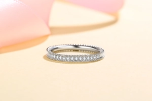 Macro shot of S925 sterling silver full moissanite ring with milgrain edge on silk background