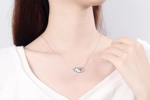 Close-up of S925 sterling silver elephant pendant necklace with moissanite on a model