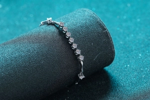 Macro shot of 925 sterling silver bracelet with round zircons and square cut gemstone