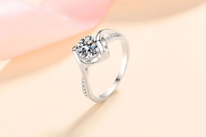 Detail shot of a S925 sterling silver moissanite ring with side stones on pink silk
