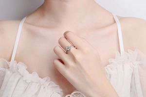 Macro shot of S925 silver moissanite ring with twisted band worn on model collarbone