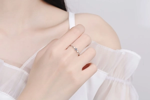 Detail of S925 silver ring with 0.1ct moissanite and hollow heart designs on finger