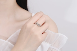 Close-up of S925 sterling silver criss cross ring with moissanite pavé on a hand