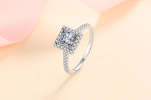 Macro shot showing 1 carat princess cut halo moissanite ring with side accent diamonds