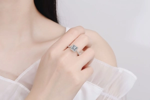 Close-up of 925 sterling silver princess cut halo moissanite ring on a female finger